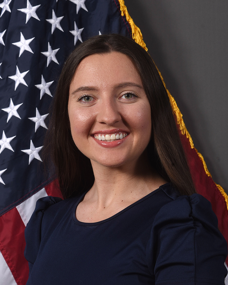 Aleeya Fitzgerald Media Specialist II in front of American Flag