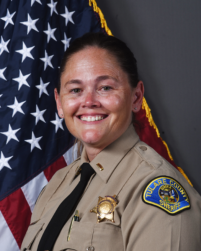 A portrait of LT. Karyse Sandoval in uniform in front of an American flag