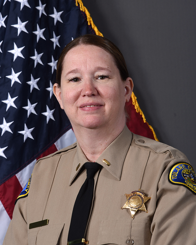 A portrait of Lt. Sara Olmos in uniform facing forward in front of American Flag